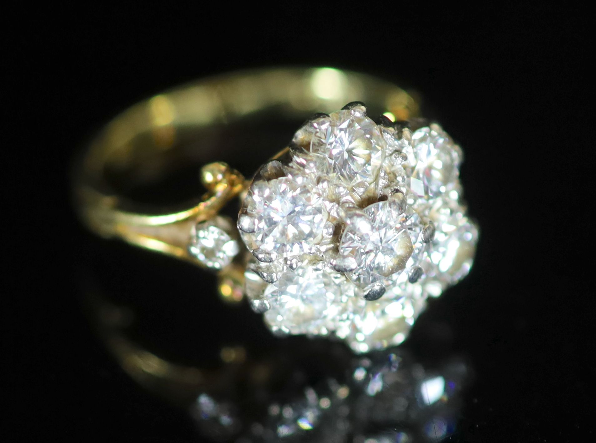 A mid 20th century gold and seven stone diamond cluster ring